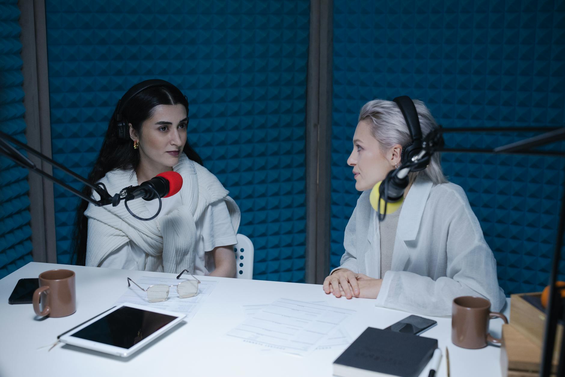 Dwie kobiety nagrywające podcast w dźwiękoszczelnym studiu