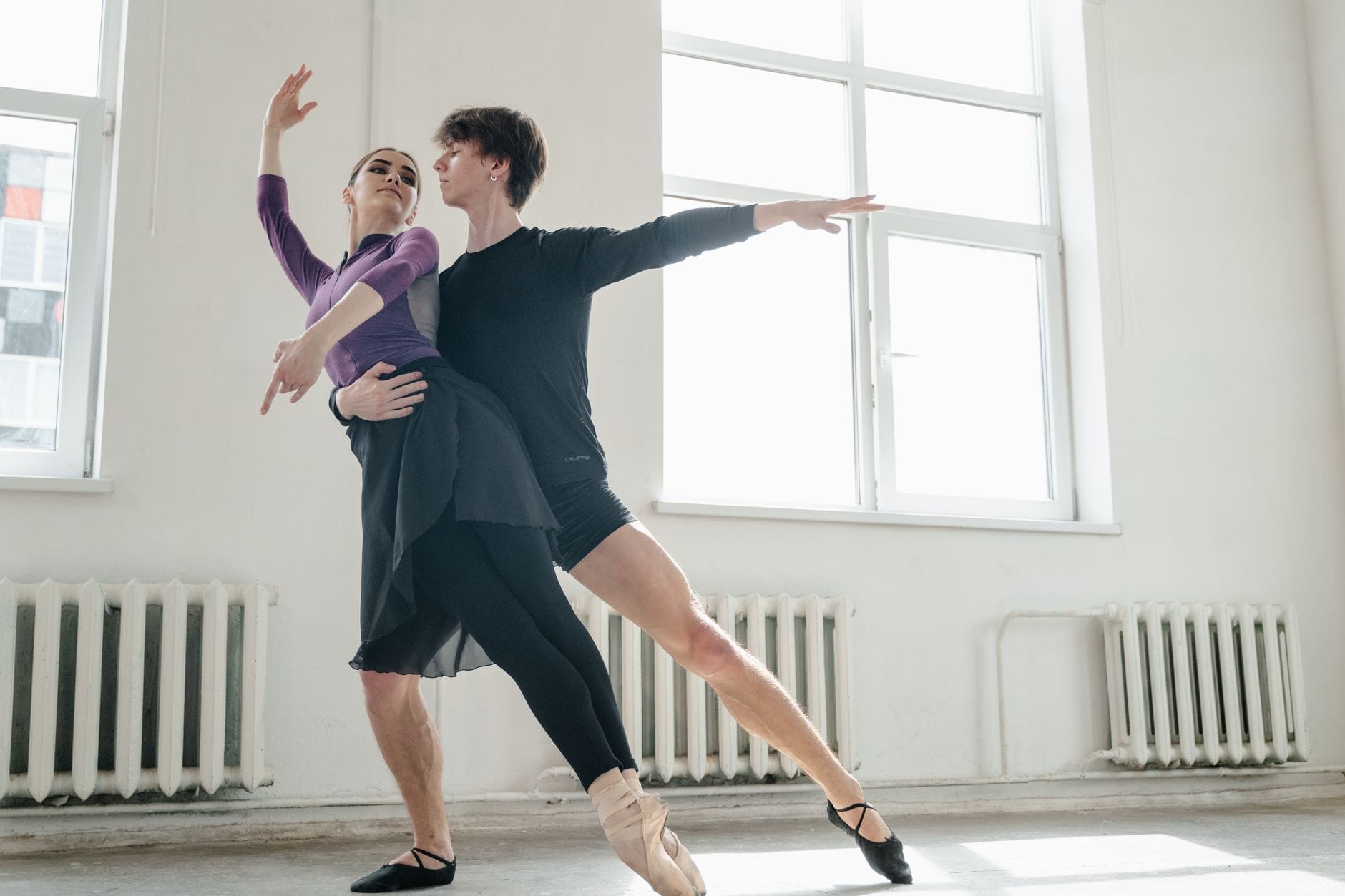 Dwoje tancerzy baletowych ćwiczy duetową choreografię w studiu