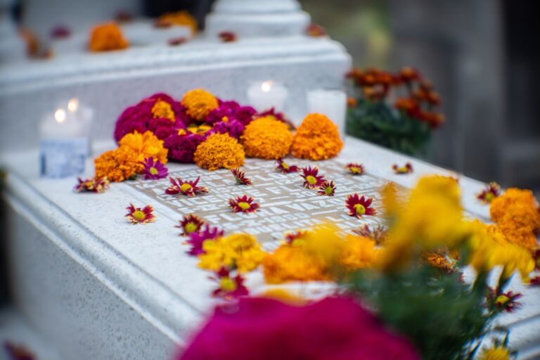 Nagrobek ozdobiony nagietkami i chryzantemami na Día de los Muertos